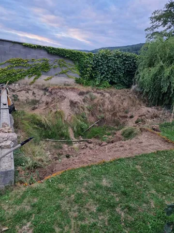 Neudržovaný svah zahrady před stavbou bazénu